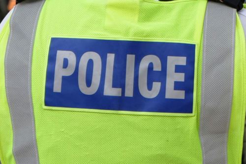 Closeup of neon yellow uniform vest with POLICE on it